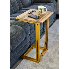 a wooden table with a cell phone on it next to a blue couch in a living room