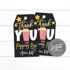 two thank tags with the words thank you for popcorn and stars on them, one is black