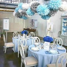 a room filled with tables covered in blue and white decorations