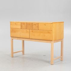 a wooden dresser sitting on top of a white floor