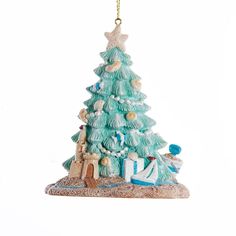 a blue christmas tree ornament hanging from a gold chain