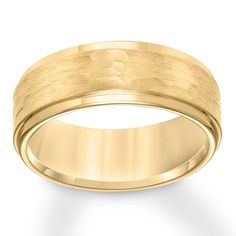 a yellow gold wedding ring on a white background