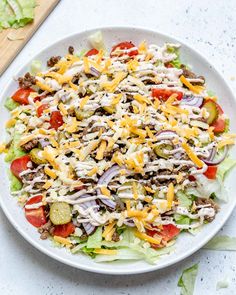 a white plate topped with a salad covered in cheese