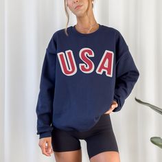 Show your patriotic spirit in our retro inspired USA sweatshirt. We love this fun bold lettering for a unique take on the classic. It's the perfect sweatshirt for all your 4th of July activities and cool summer evenings.  A sturdy and warm sweatshirt bound to keep you warm in the colder months. A pre-shrunk, classic fit sweater that's made with air-jet spun yarn for a soft feel and reduced pilling. * 50% cotton, 50% polyester * Pre-shrunk * Classic fit * 1x1 athletic rib knit collar with spandex Vintage Crew Neck Tops For 4th Of July, Patriotic Crew Neck Top Made In Usa, Patriotic Crew Neck Top With Letter Print, American Streetwear Tops With Letter Print, Retro Crew Neck Top With Letter Print, American Style Letter Print Tops For Streetwear, Patriotic Crew Neck Top For Streetwear, American Crew Neck Top With Text Print, American Flag Tops For Fall