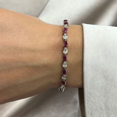 This Beautifully Crafted Tennis Bracelet Features Pear Shaped Rubies With Baguette And Round Cut Diamonds In Prong And Channel Setting. Crafted In 14k White Gold. Total Diamond Weight: 1.58 Carats. Diamond Quality: G-H Color And Si Clarity. Total Ruby Weight: 4.68 Carats. Length: 7 Inches. Width: 3.8mm. Total Weight: 9.38 Grams. Bracelet Closes Securely With A Box Clasp. This Tennis Bracelet Is A Timeless Piece That Holds A Place In The Collection Of Every Jewelry Lover. Comes With A Presentable Ruby Tennis Bracelet, Elegant Red Tennis Bracelet For Anniversary, Elegant Ruby Tennis Bracelet For Formal Occasions, Fine Jewelry Red Diamond Bracelet For Formal Occasions, Red Fine Jewelry Tennis Bracelet For Wedding, Elegant Pear-shaped Diamond Bracelet, Red Tennis Bracelet For Wedding, Red Fine Jewelry Tennis Bracelet For Formal Occasions, Formal Red Diamond Jubilee Bracelet