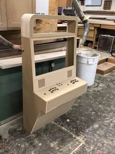 an old computer sitting on top of a counter in a room filled with unfinished furniture