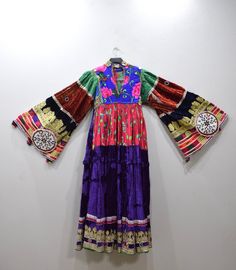 A beautiful Handmade Tribal Kutchi Dress from Afghanistan. Embellished with detailed beading and embroidery this dress has a rich velvet embellished skirt with gold and silver lame, mirrors, beading and embroidery. Kutchi embroidery has approximately 16 different types of stitches and styles and it is these variations that allow for the differentiation between the communities. Embroidery techniques are passed down from mother to daughter. The traditional dress of Afghanistan was very tremendous Festive Traditional Embroidered Dress, Bohemian Floor-length Dresses With Gold Embroidery, Festive Multicolor Embroidered Embellished Dress, Festive Multicolor Embellished Embroidered Dress, Bollywood Style Hand-embellished Dresses For Festivals, Festive Floor-length Velvet Dress, Traditional Embellished Multicolor Embroidered Dress, Traditional Embellished Dress With Multicolor Embroidery, Traditional Embellished Embroidered Dress With Multicolor Embroidery