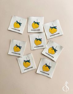 six handmade tea bags with lemons printed on the front and back, sitting on a table