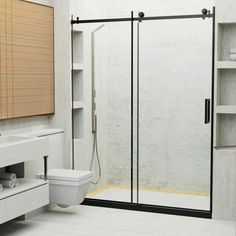 a bathroom with a walk in shower next to a white toilet and sink under a window