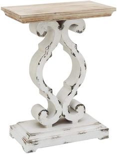 an old white table with wooden top and scroll design on it's base, against a white background