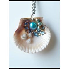 a seashell with pearls and other beads on a chain