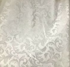 a white and silver wallpaper with an intricate design on the bottom half of it