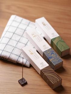 three wooden boxes sitting on top of a table next to a white and blue towel