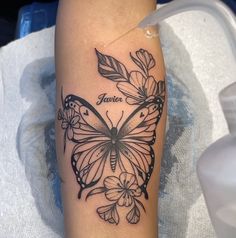 a black and white photo of a butterfly with the word tattoo on it's leg