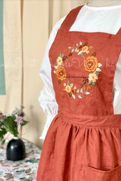 an orange apron with flowers on it