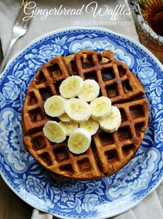 a blue and white plate topped with waffles covered in banana slices