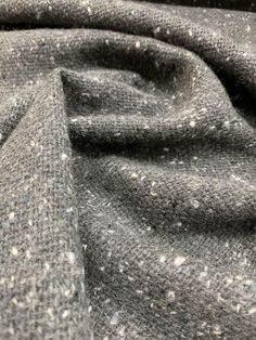 the fabric is grey and white speckled with small dots on it's surface