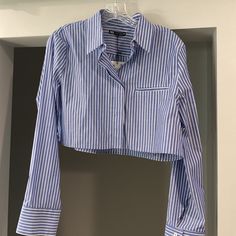 This Is A Cropped Oxford Shirt, Originally Purchased From Zara. The Shirt Was Originally Purchased For $39.90 As Shown On The Attached Tag. This Shirt Is A Beautiful Oxford Shirt, Blue In Color With White Stripes. It Buttons Down The Front With 5 Buttons. The Sleeves Also Button With Two Buttons. The Shirt Is Slightly Longer In The Back. There Appears To Be A Pocket On The Left Breast But This Pocket Is Non-Functional. This Shirt Runs A Bit Small. My Daughter Usually Wears A Small Or An Extra-Sm Oxford Shirt, Zara Tops, White Stripe, Oxford, Zara, Stripes, Blue And White, Brand New, Crop Tops