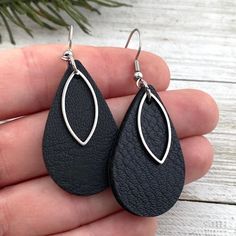 a pair of black leather tear shaped earrings