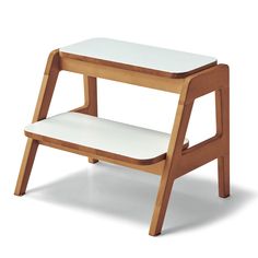 a wooden step stool with white cushions on the top and bottom shelf, against a white background