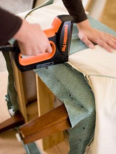 a person ironing fabric on an ironing board with a hand held electric iron