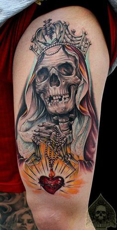 a woman's thigh with a skull and crown tattoo design on it, as well as a heart