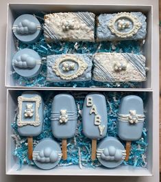 two boxes filled with blue and white decorated cookies