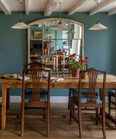 a dining room table with four chairs and a mirror on the wall above it that says, what makes this house home?