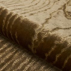 a close up view of a brown and beige rug with wavy lines on it's surface