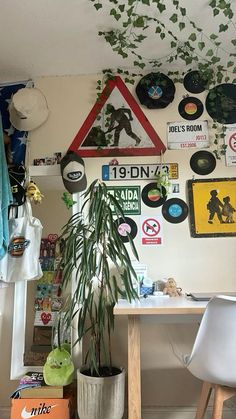 a room filled with lots of different types of signs and plants on the wall next to a table