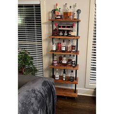 a shelf with liquor bottles on it next to a couch in a living room area