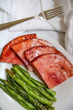 bacon and asparagus on a white plate with silverware