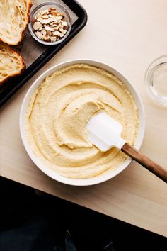 a bowl of hummus next to some toasted bread