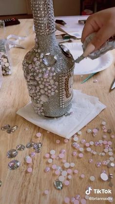 a person is doing something on a table with beads and other items around it, including a vase