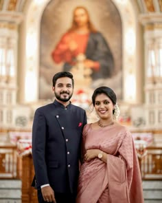 a man and woman standing next to each other in front of a painting