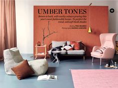 a living room filled with lots of furniture next to a wall covered in orange and pink