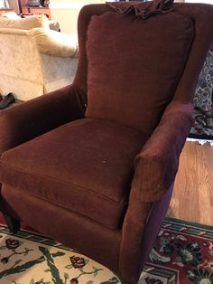 a brown chair sitting on top of a rug