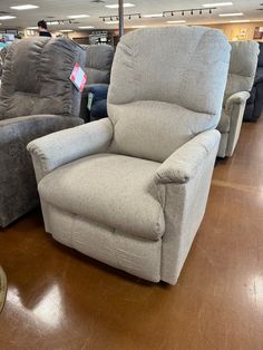 two recliners are sitting in the middle of a store floor with other reclining chairs