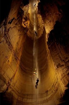 two people standing in the middle of a cave