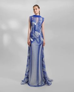 Indulge in luxury with this exquisite long royal blue evening dress, tailored to accentuate your silhouette with its slim-cut design. Crafted for elegance, it features an embroidered pattern that exudes sophistication. The reversed collar adds a unique touch, complemented by an alluring open back and a graceful tail. Unique Long Dress, Sleeveless Blue Evening Gown, Blue Sleeveless Evening Gown, Blue Fitted Dress For Gala, Blue Maxi Length Dress For Gala, Royal Fitted Gala Gown, Blue Floor-length Evening Dress With Back Opening, Royal Fitted Gown For Gala, Elegant Royal Blue Evening Dress For Banquets