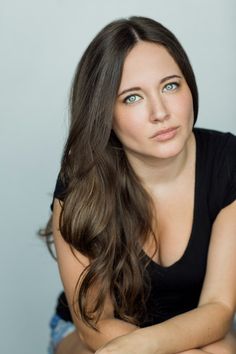 a woman with long brown hair sitting down