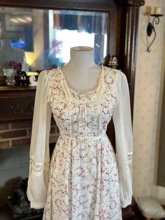 "From the lace collars and sleeves to the beautiful pearl buttons, everything on this gorgeous Gunne Sax dress is original and in beautiful condition. The only small sign of wear is a very fixable unstitched seam on the back of the neckline (see last image) and a very small brown stain the front that is hardly noticeable; I did not address either as it's a project better suited for a professional.  I was unable to find any stains or rips otherwise. This dress is pictured on a 5'9\" mannequin and Fitted Dresses With Lace Sleeves And Square Neck, White Dress With Lace Sleeves And Square Neck, Long Sleeve Vintage Dress With Lace Patchwork, Elegant Long Sleeve Vintage Dress With Lace Patchwork, Long Sleeve Lace Patchwork Vintage Dress, Feminine Long Sleeve Dress With Lace Bodice, Feminine Long Sleeve Dress With Lace Collar, Cream Long Sleeve Dress With Lace Collar, Feminine Fitted Dresses With Lace Trim