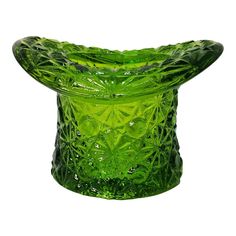 a green glass vase sitting on top of a table