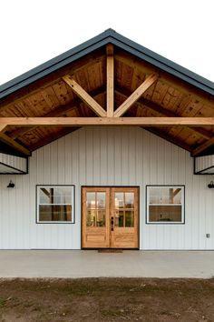 a large white building with wooden doors and windows