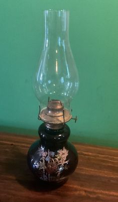 an old fashioned oil lamp sitting on top of a wooden table