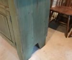 an old wooden cabinet sitting next to a chair