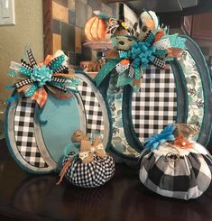 three decorative pumpkins sitting on top of a table next to each other with bows