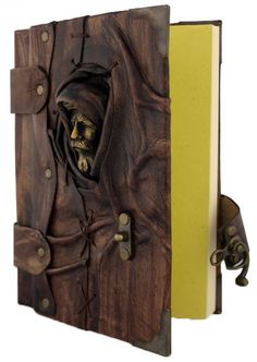 a wooden book with a skeleton in it's face and a yellow cover on the front