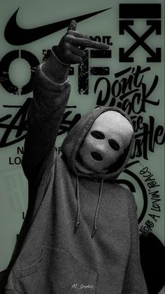 a person in a hoodie with a mask on and pointing to the side while wearing a face mask