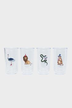 three shot glasses with different animals on the side and one has a snake in it